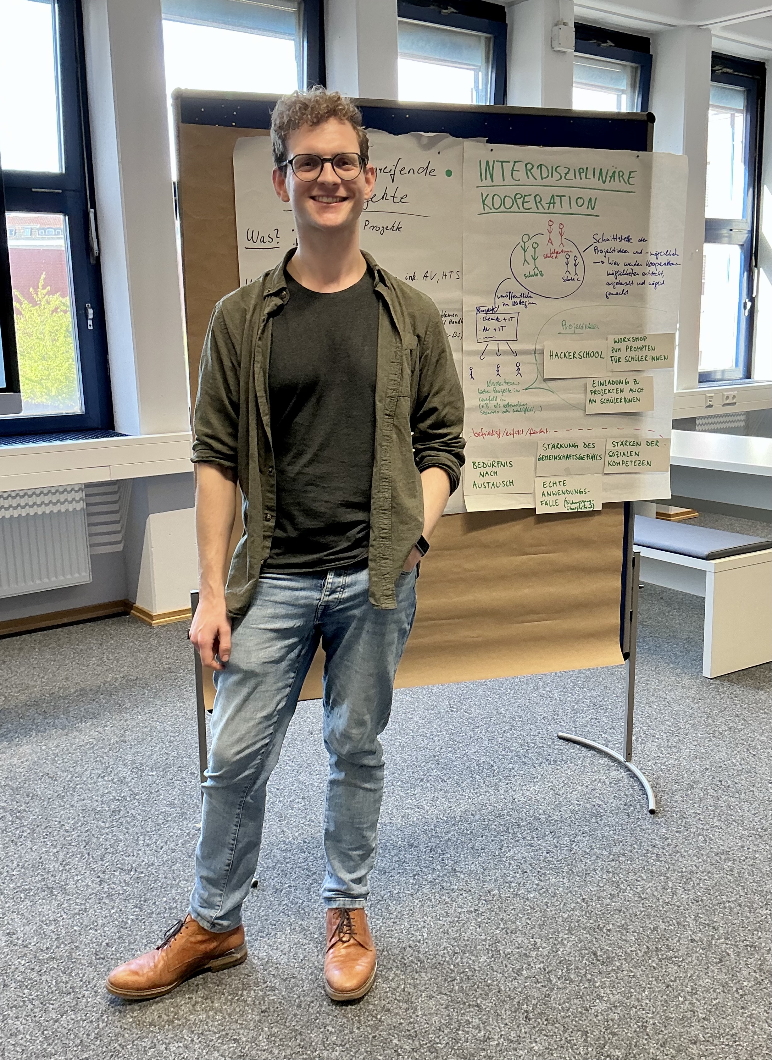 Mensch steht vor Pinnwand, auf der Ergebnisse aus einem Workshop zu sehen sind.