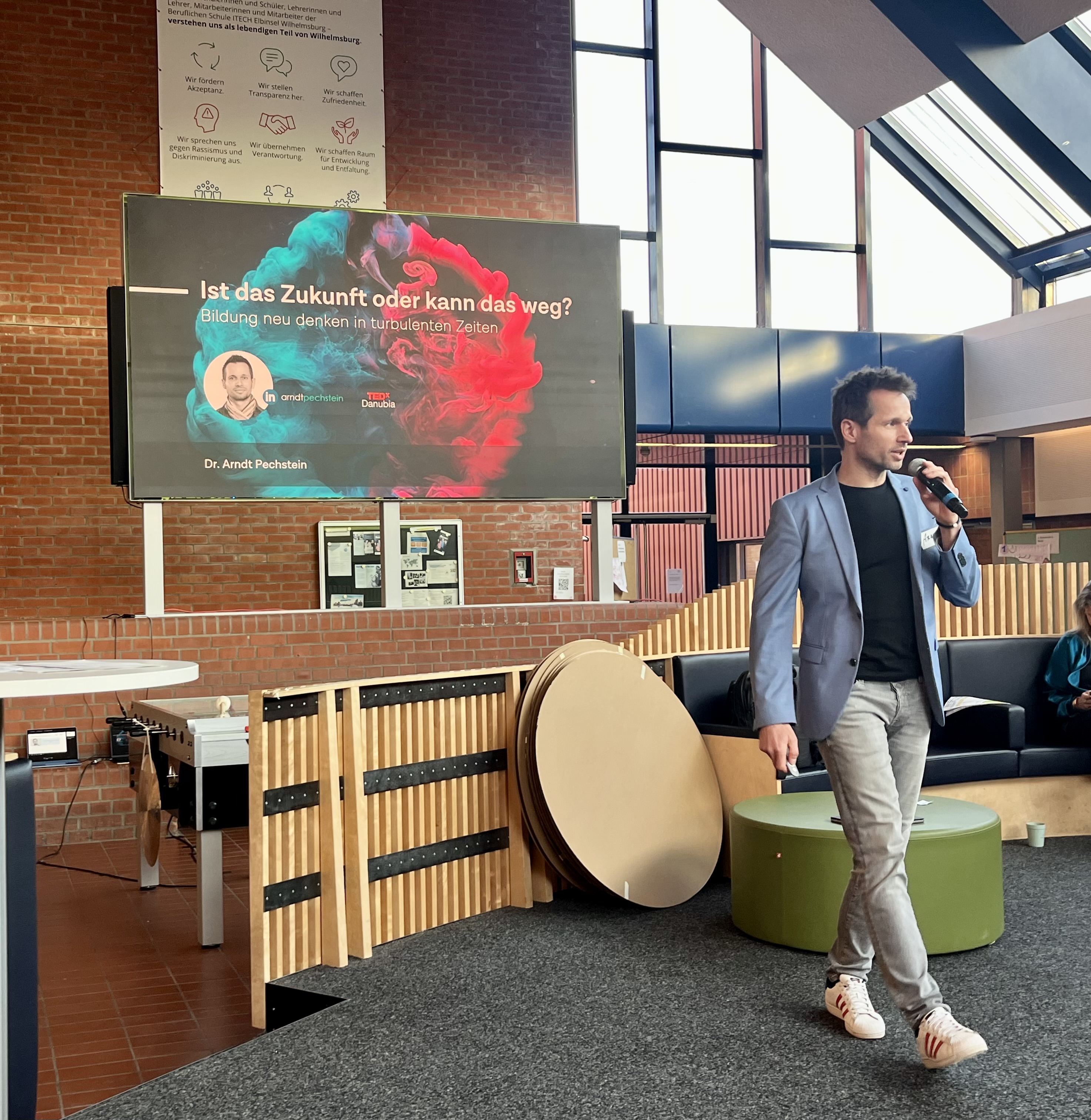 Auf der Bühne steht Dr. Pechstein und spricht in ein Mikro.
