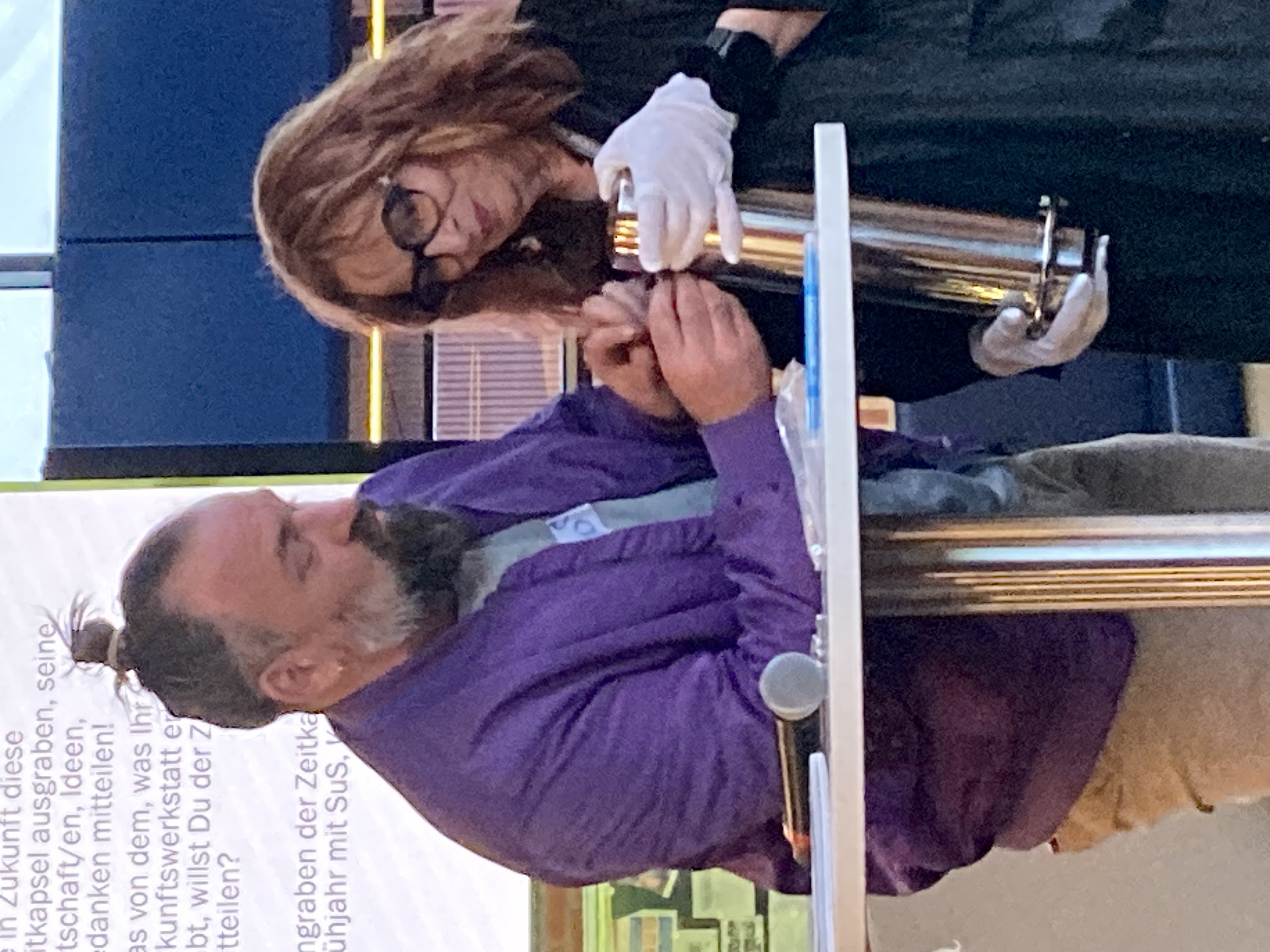 Ein Mann und eine Frau halten eine Kapsel und befüllen diese mit Zetteln.